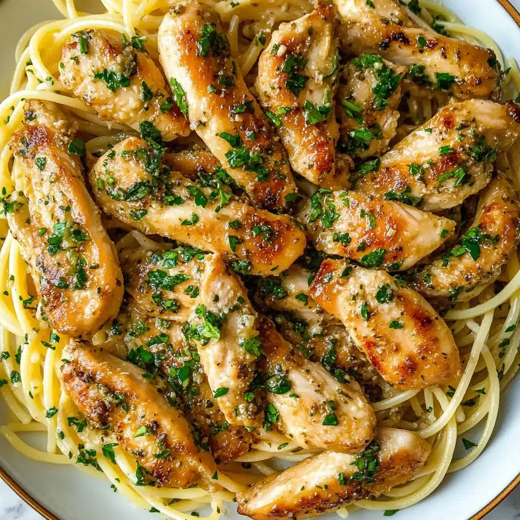 Chicken Scampi Pasta, easy chicken pasta recipes, lemon garlic chicken pasta, quick weeknight dinner, restaurant-style pasta The dish shows a white plate full of light yellow spaghetti noodles as the bottom layer, topped with many pieces of golden brown cooked chicken strips scattered all over. Finely chopped green herbs and small bits of garlic are sprinkled evenly on the chicken and noodles, adding green and pale white colors. The chicken looks slightly crispy with a shiny texture from a light sauce that covers the top. The whole scene rests on a white marbled surface.