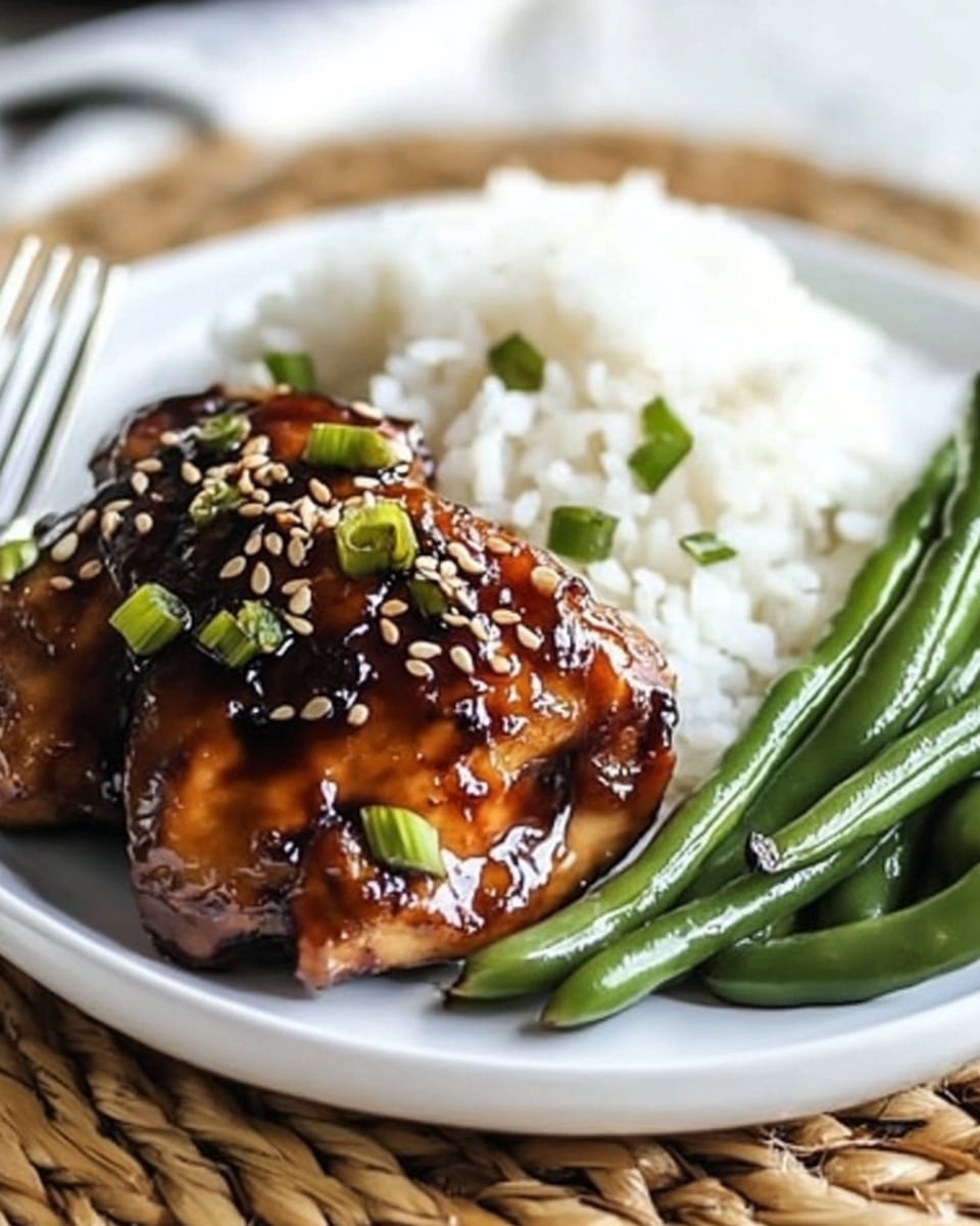 In this close-up image, seven pieces of glazed, cooked chicken are arranged evenly in a black pan, each piece browned and shiny with a dark caramelized sauce. The chicken pieces are topped with small bright green chopped scallions and sprinkled with light-colored sesame seeds, adding texture and color contrast. The pan sits on a woven mat, and the background includes a soft stack of white plates and a light-colored object out of focus. The overall look shows a rich, savory meal with a glossy finish and fresh green garnish. Photo taken with an iphone --ar 4:5 --v 6.1