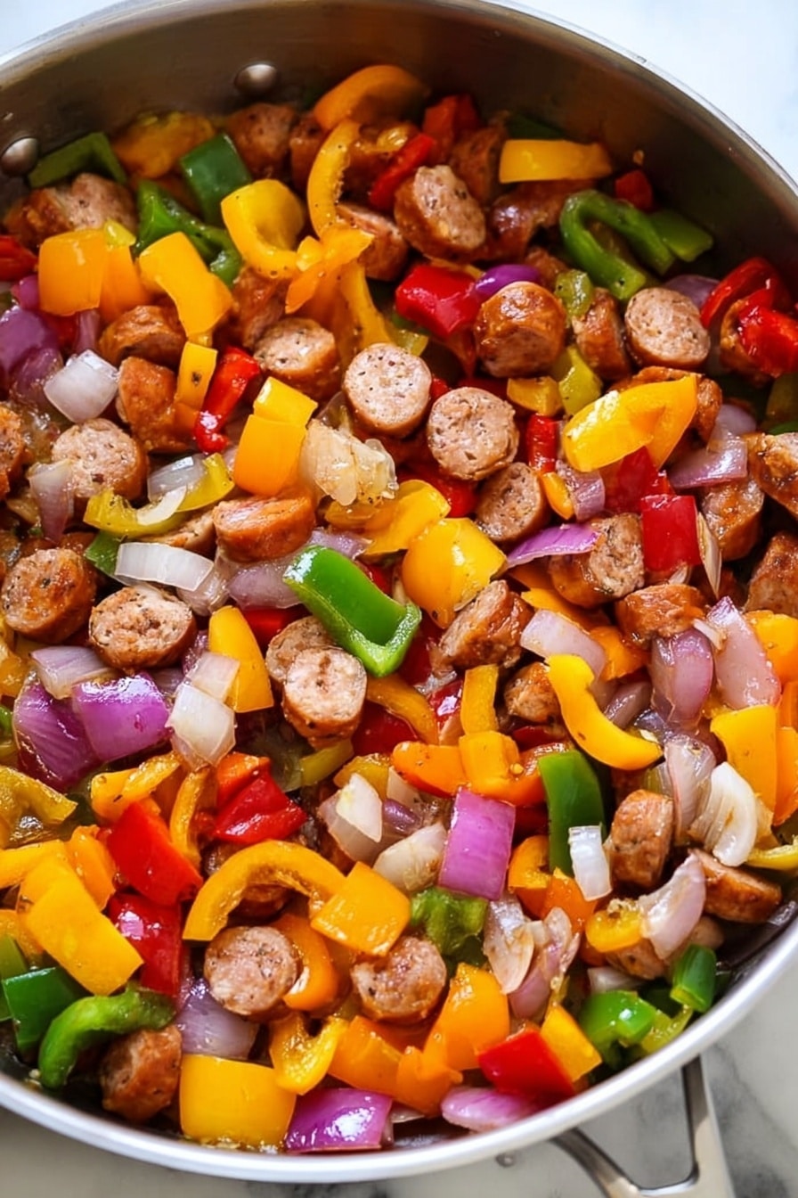 The image shows a pan filled with cooked sausage slices and mixed vegetables. There are three clear layers: the first layer is round sausage pieces that are browned and cooked, scattered evenly throughout the pan. The second layer consists of diced bell peppers in three colors—yellow, red, and green—each piece vibrant and slightly softened from cooking. The third layer includes chopped onions that are translucent with hints of light purple and white, mixed closely with the peppers and sausage. The pan itself is shiny metal on a white marbled texture surface. photo taken with an iphone --ar 2:3 --v 7 - Lightning-Fast Cheesy Three-Pepper Ravioli with Italian Sausage, quick Italian pasta recipe, easy cheesy sausage pasta, vibrant pepper ravioli, weeknight dinner ideas