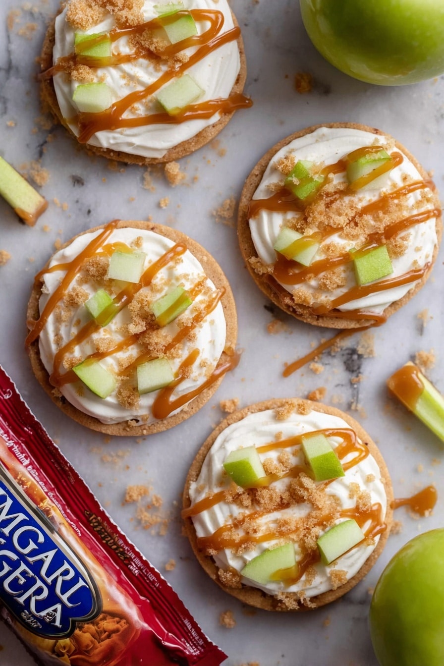 There are four round cookies on a white marbled surface, each cookie topped with a thick swirl of white cream. On top of the cream are small green apple pieces and light brown crumbly bits. Each cookie has thin lines of caramel-colored sauce drizzled over the cream and toppings. A few crumbs are scattered around the cookies. One green apple and a red bag of Imperial Sugar lie near the cookies. In the middle of the cookies is a small stick of green apple with the caramel sauce drizzled on it. photo taken with an iphone --ar 2:3 --v 7 - Caramel Apple Cookies, Crumbl Copycat Cookies, Apple Cinnamon Cookies, Easy Caramel Cookies, Fall Dessert Recipes