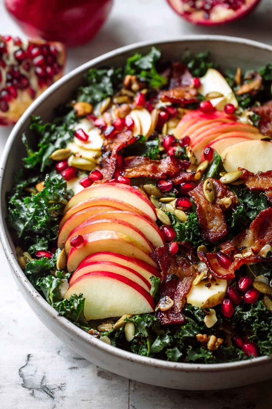 A white bowl filled with a fresh salad is placed on a white marbled texture. The bottom layer has dark green curly kale. On top, there are thinly sliced red apples arranged in small stacks showing red and light yellow skin with white inside. Bright red pomegranate seeds are scattered all over the salad, adding small round pops of color. There are pieces of crispy golden-brown bacon spread unevenly across the bowl. Small roasted pumpkin seeds are sprinkled lightly over the salad, giving a crunchy texture. The colors are deep green, red, and brown with a mix of soft and crispy textures. Photo taken with an iphone --ar 2:3 --v 7 - Fall Harvest Honeycrisp Apple and Kale Salad, autumn apple kale salad, healthy fall salad, seasonal apple and kale salad, caramelized shallot vinaigrette salad