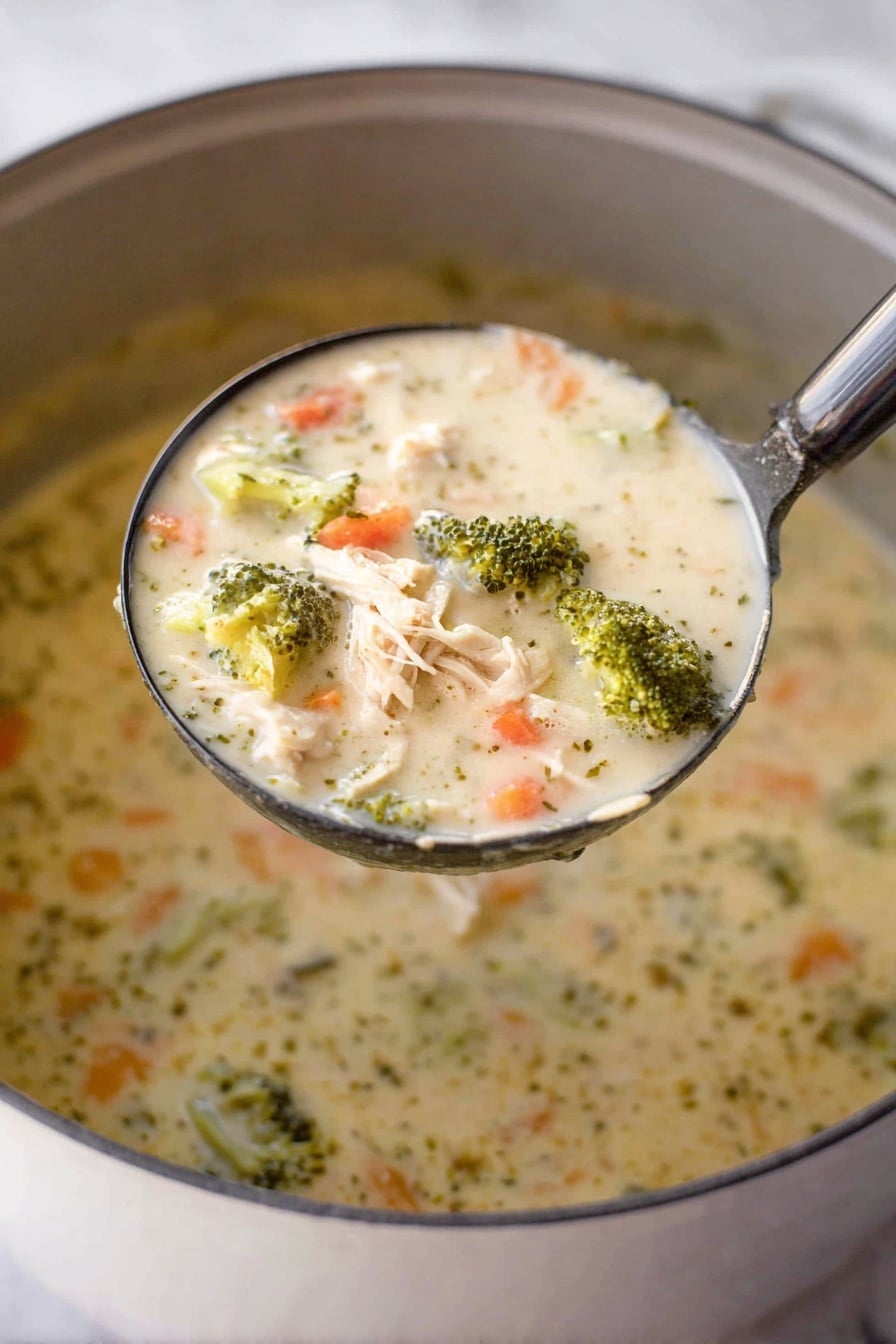 A close-up shot shows a ladle filled with creamy chicken and broccoli soup held above a pot. The soup has a thick, creamy texture with visible chunks of light beige shredded chicken, bright green broccoli florets, and small orange carrot pieces mixed throughout the light cream-colored broth. The surface beneath the pot is a white marbled texture. Photo taken with an iphone --ar 2:3 --v 7 - Creamy Chicken and Broccoli Soup, hearty chicken broccoli soup, easy chicken and broccoli dinner, comforting creamy soup recipe, healthy chicken broccoli soup