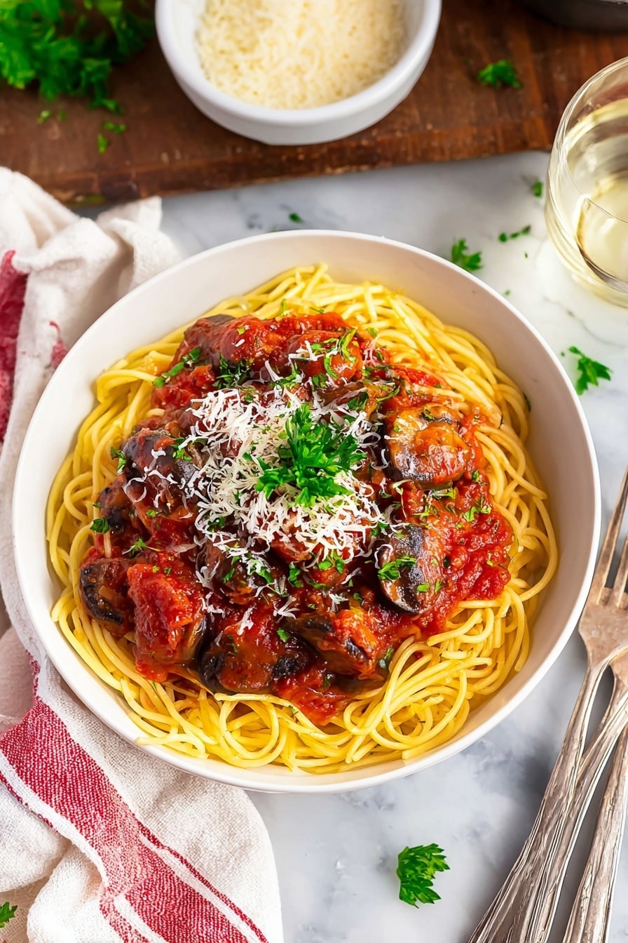 A white bowl holds three main layers: the bottom layer is a bed of thin, pale yellow spaghetti noodles, slightly tangled; the middle layer is a rich, chunky red tomato sauce with visible pieces of cooked mushrooms and finely diced orange carrots; the top layer is a light sprinkle of white grated cheese and small green parsley leaves scattered across the dish for color contrast, with a larger parsley sprig placed at the back. The bowl sits on a white marbled textured surface, with a blurred glass of pale white liquid and bread rolls visible in the background. photo taken with an iphone --ar 2:3 --v 7 - Slow Cooker Chicken Cacciatore, Italian chicken slow cooker, Easy chicken cacciatore recipe, Crockpot chicken dinner, flavorful Italian chicken