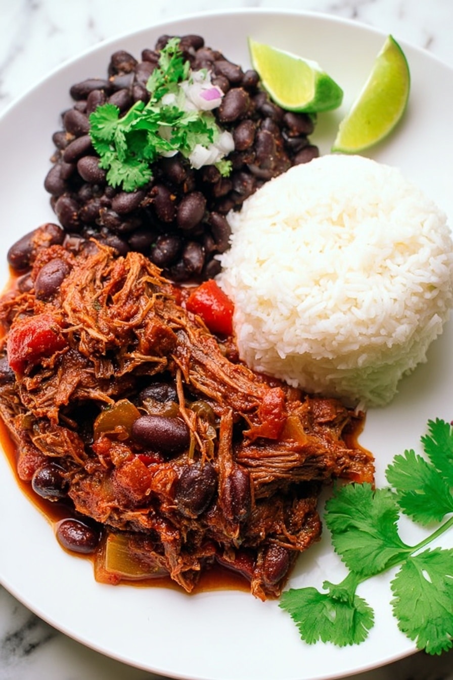 A white plate with three main layers: on the top right, a mound of white fluffy rice with a soft texture; on the top left, a scoop of cooked black beans mixed with small onion pieces, topped with a sprig of fresh green cilantro; and covering the bottom half of the plate, a rich, thick reddish-brown stew with shredded meat and chunks of vegetables like olives and red peppers. On the right edge of the plate, a lime wedge adds a touch of bright green. Fresh cilantro leaves lie on the white marbled surface near the plate. Photo taken with an iphone --ar 2:3 --v 7 - Slow Cooker Ropa Vieja, Cuban shredded beef stew, Cuban beef recipes, easy Cuban dinner, slow cooker beef stew