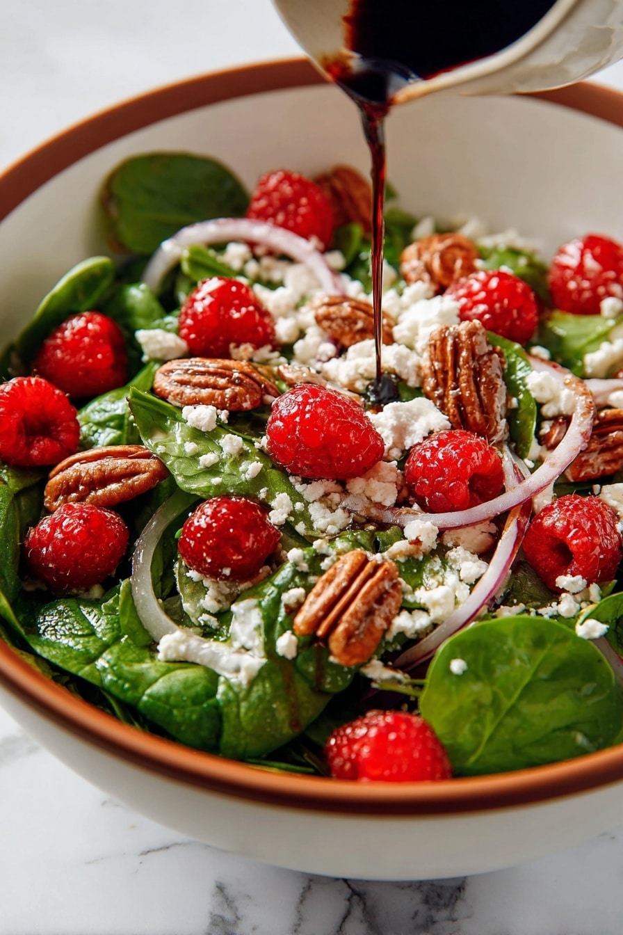This image shows a fresh salad in a white bowl with a wooden spoon on the side. The salad has several layers and colors: the base is bright green spinach leaves mixed with thin slices of purple onion; scattered on top are red raspberries and brown pecan nuts adding texture; white crumbled goat cheese is spread evenly across the salad, with dark balsamic glaze drizzled over everything, giving a shiny and rich look. The bowl rests on a blue cloth, all placed on a white marbled surface. Photo taken with an iphone --ar 2:3 --v 7 - Sweet and Tangy Spinach Salad with Goat Cheese, Raspberries, and Toasted Pecans, spinach salad with goat cheese and raspberries, easy fruit and nut salad recipes, healthy berry spinach salad, quick gourmet salad ideas