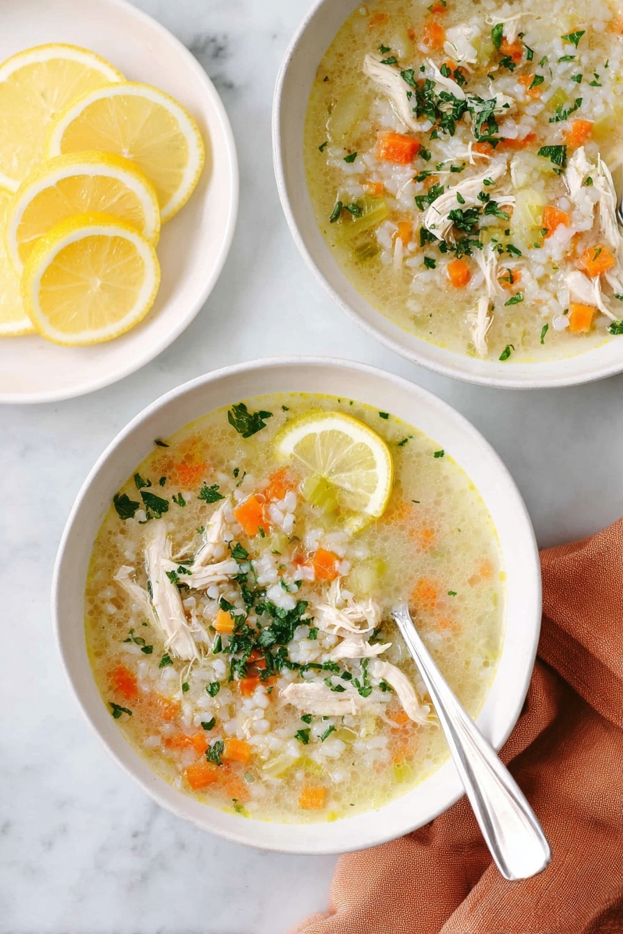 Two white bowls filled with chicken soup placed on a white marbled surface. Each bowl has a light yellow broth with shredded chicken pieces, small diced orange carrots, small green celery pieces, and white rice, topped with chopped green herbs. One bowl shows a silver spoon resting inside the bowl on the right side. A lemon wedge sits on the edge of the front bowl. Next to the bowls, there is a white plate holding several lemon slices. A soft orange cloth napkin lies under the front bowl. Photo taken with an iphone --ar 2:3 --v 7 - Lemon Chicken Rice Soup, Lemon Chicken Soup, Chicken and Rice Soup, Lemon Chicken Broth, Hearty Lemon Chicken Soup