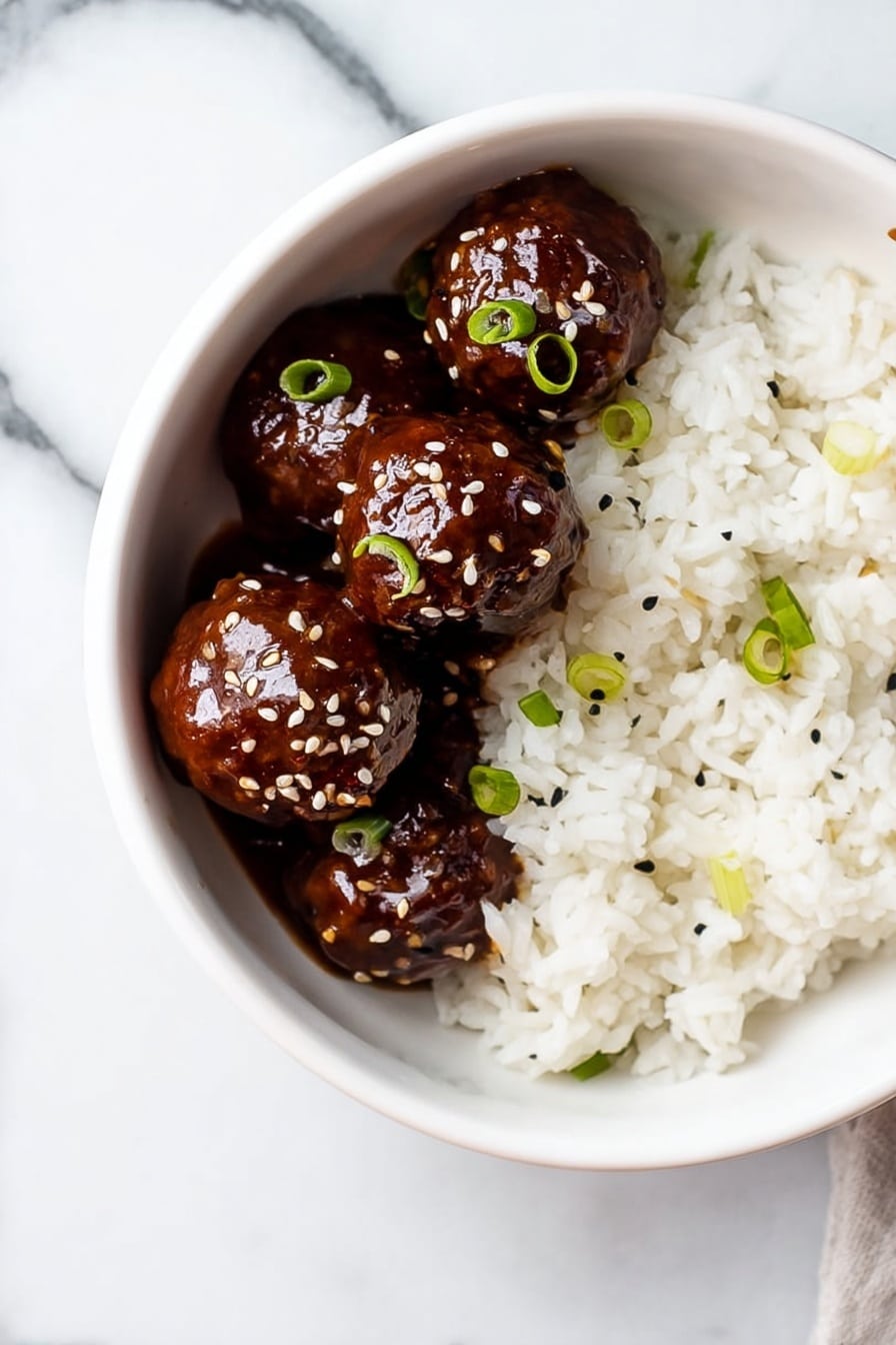 A white bowl sits on a white marbled surface, filled halfway with soft, fluffy white rice that has a few small green onion slices scattered on top. On one side of the bowl, four shiny, dark brown meatballs covered in a thick, glossy sauce are neatly placed. The meatballs are also sprinkled with sesame seeds and small pieces of green onion, adding contrast to their smooth, rich texture. photo taken with an iphone --ar 2:3 --v 7 - Sticky Honey Garlic Meatballs, Honey Garlic Meatballs, Easy Meatball Recipes, Quick Dinner Ideas, Sweet and Savory Meatballs