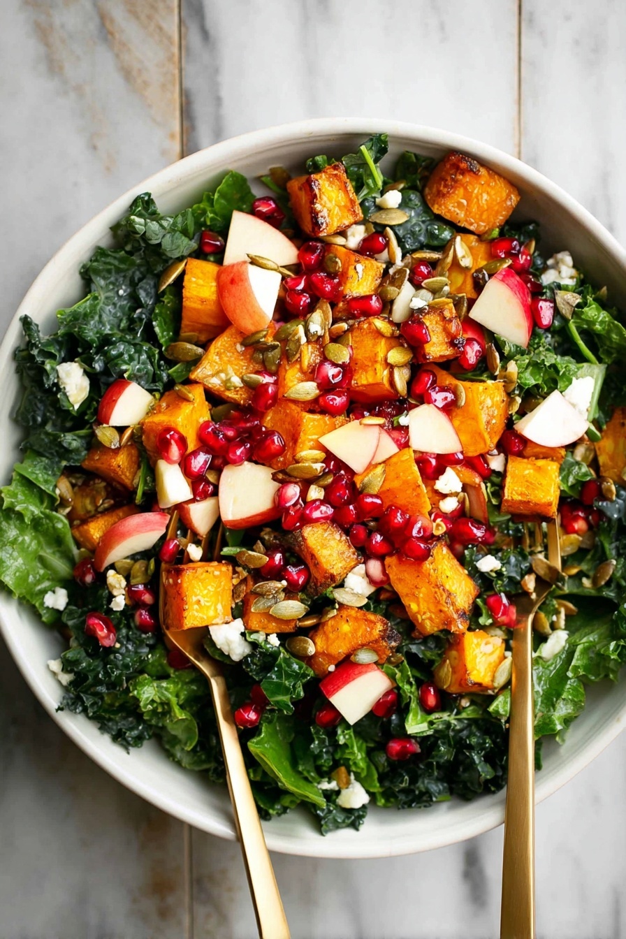 A white bowl filled with a colorful salad sits on a white marbled surface. The salad has three main layers: at the bottom, there are dark green kale leaves, fresh and leafy. On top of the kale, there are medium-sized orange roasted cubes of squash scattered around. Mixed in with these are small pieces of red apple with white inside, bright red pomegranate seeds, and some white small chunks of cheese. The salad is finished with some brown pumpkin seeds sprinkled evenly. Two metallic gold forks are placed inside the bowl, one on each side. Photo taken with an iphone --ar 2:3 --v 7 - Roasted Butternut Squash and Apple Salad, fall salad recipe, healthy roasted vegetable salad, easy autumn salad, flavorful winter salad