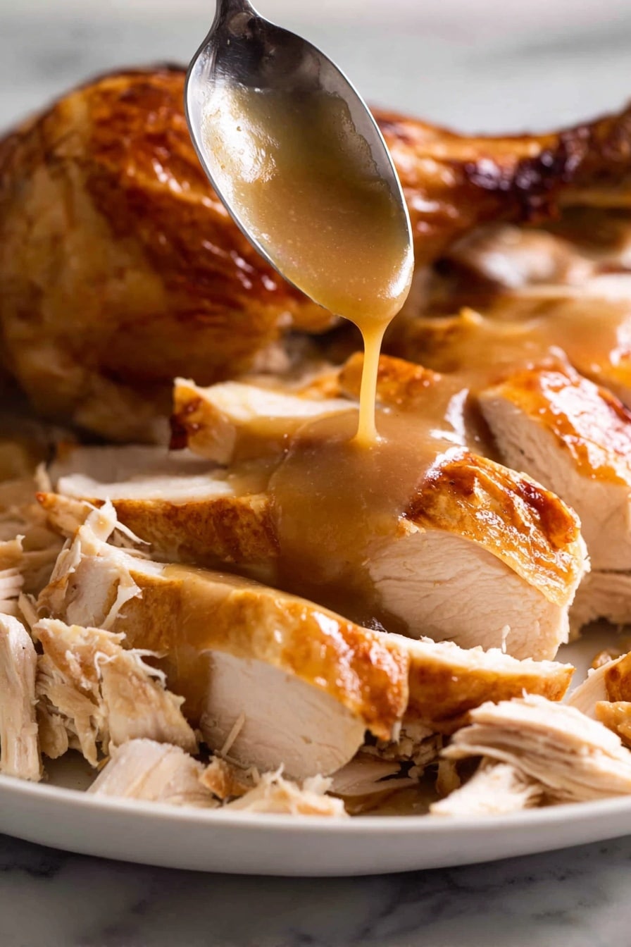 A white plate is filled with sliced roasted chicken with a shiny, golden-brown skin. The chicken is cut into thick pieces, showing tender, white meat inside. At the center, smooth brown gravy is being poured from a spoon, slowly flowing over the chicken slices, adding a glossy layer. Some shredded chicken pieces with light beige tones are placed around the sliced chicken, creating a mix of textures. In the background, part of a roasted chicken drumstick with crispy skin is visible. The entire scene is set on a white marbled surface. Photo taken with an iphone --ar 2:3 --v 7 - KFC copycat flavor gravy, homemade gravy recipe, quick gravy recipe, easy comfort food gravy, savory gravy for chicken and mashed potatoes