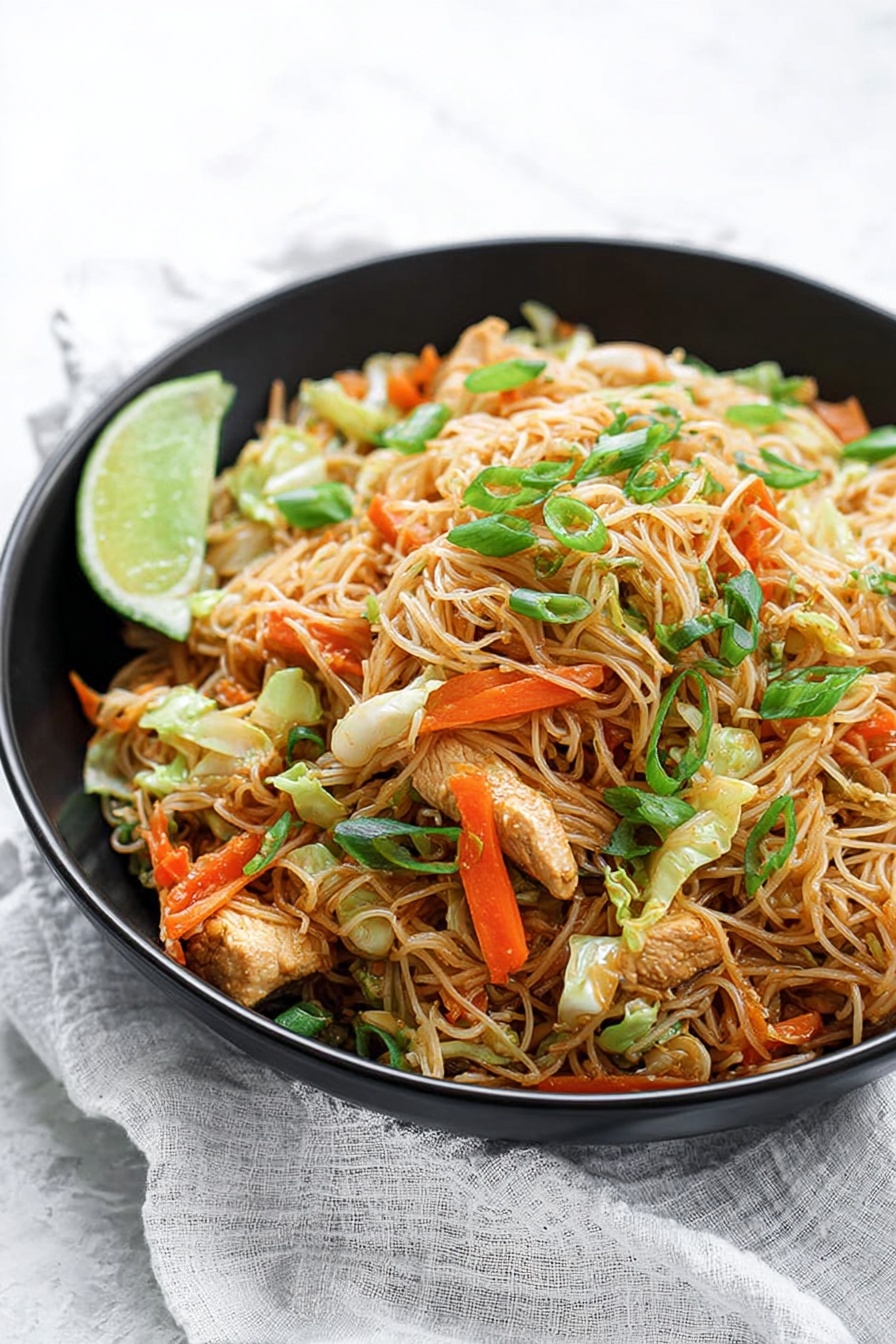 The image shows a large black wok filled with a heap of cooked thin rice noodles mixed with small pieces of light brown chicken, bright orange carrot strips, green onion stalks, and light green cabbage pieces. A woman's hand holds a wooden spatula lifting a tall mound of the noodles, showing the mix’s soft and slightly oily texture. The background has a white marbled surface with a wooden cutting board and kitchen items softly blurred. The noodles and vegetables create a colorful and textured heap inside the wok. Photo taken with an iphone --ar 2:3 --v 7 - Easy Chicken and Pork Pancit, Filipino Pancit Recipe, Simple Chicken and Pork Noodles, Quick Filipino Stir-Fry, Savory Pancit with Chicken and Pork