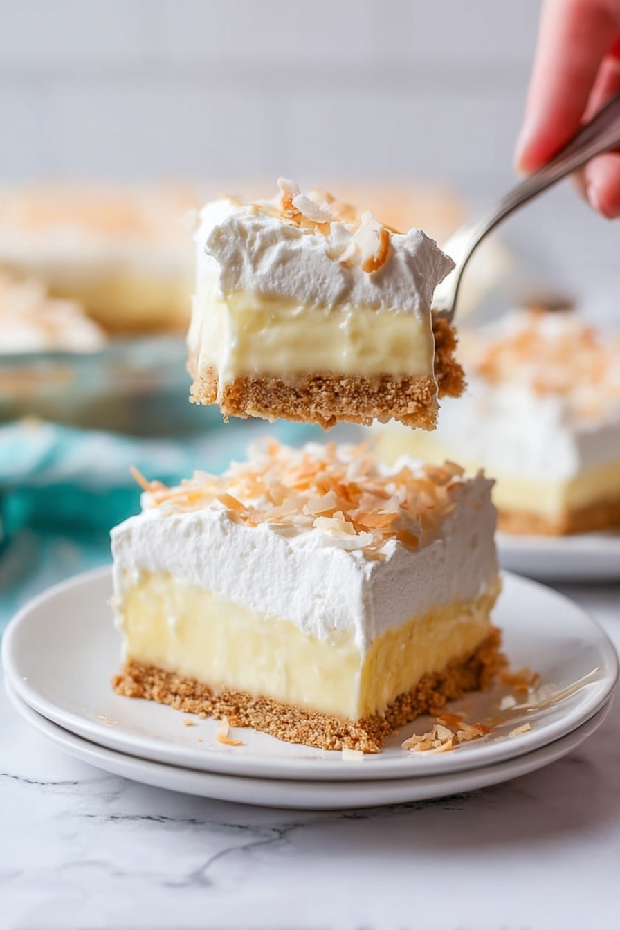 The image shows a slice of a three-layer creamy dessert on a white plate set on a white marbled surface. The bottom layer is a crumbly light brown crust. The middle layer is thick and pale yellow with a smooth texture like pudding. The top layer is white and fluffy, appearing like whipped cream, sprinkled lightly with small toasted shreds that look like coconut. A woman's hand holds a fork above the plate, lifting a piece of the dessert that clearly shows all three layers in a close-up view. The background is softly blurred, with more slices of the dessert visible. photo taken with an iphone --ar 2:3 --v 7 - Coconut Cream Pie, Coconut Cream Pie Recipe, Easy Coconut Pie, Homemade Coconut Pie, Coconut Dessert