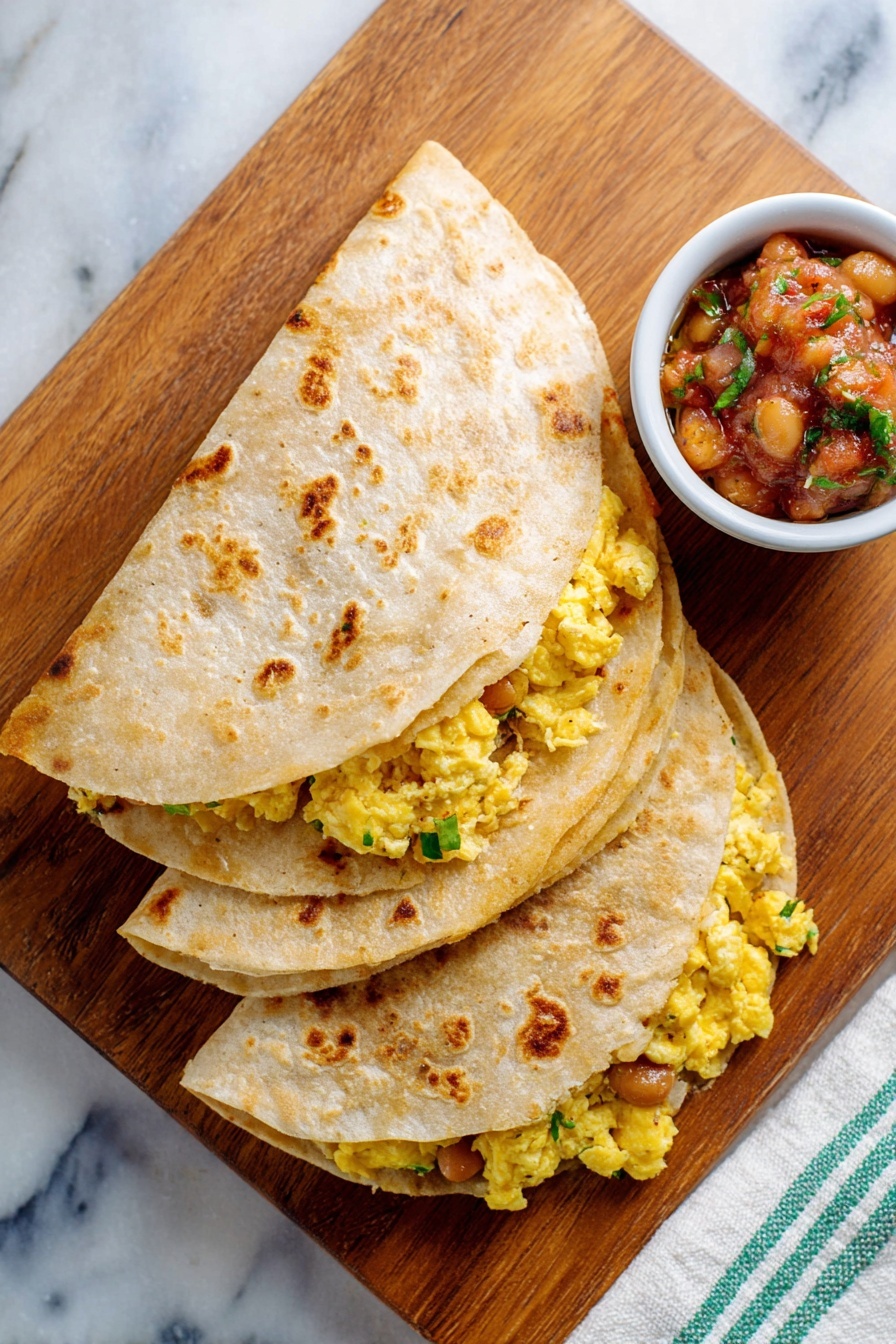 Two folded tortillas, each with two layers visible: the outer layer is a light tan with toasted brown spots, and inside there is a bright yellow scrambled egg mixture with gooey melted cheese and brown beans mixed with bits of green herbs, all peeking out slightly from under the tortillas. Behind the tortillas is a white bowl with blue patterns filled with chunky salsa showing red tomato, green herbs, and other diced vegetables. Everything is on a wooden board placed on a white marbled surface. Photo taken with an iphone --ar 2:3 --v 7 - Cheddar Egg Breakfast Quesadilla, breakfast quesadilla recipes, quick breakfast ideas, cheesy egg breakfast, easy brunch recipes