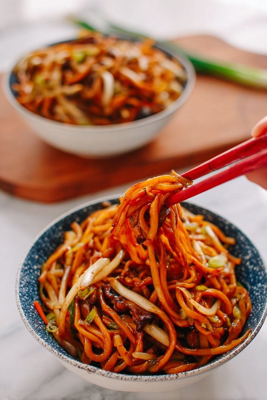 A bowl of noodles sits on a white marbled surface, filled with thick, orange-brown noodles mixed with thin white and light tan vegetables, all coated in a shiny sauce. A woman's hand is holding red chopsticks lifting a tangled cluster of noodles with bits of vegetables and darker brown mushroom-like pieces peeking through. In the background, another bowl filled with the same noodle dish is slightly blurred. The bowls are white with a blue speckled pattern on the outside, and a wooden cutting board with some green onion is faintly seen behind them. photo taken with an iphone --ar 2:3 --v 7 - Restaurant-Style Chicken Lo Mein, chicken lo mein recipe, Chinese chicken noodle stir-fry, homemade lo mein with chicken, easy Chinese chicken lo mein