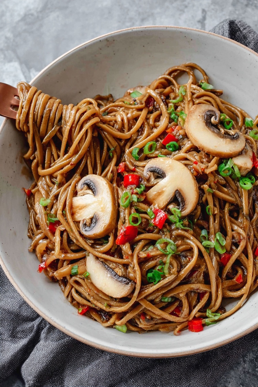 A white bowl is filled with thick noodles coated in a glossy brown sauce, mixed with small pieces of red bell pepper and garnished with finely chopped green onions. On top, there are three large slices of light brown mushrooms with darker edges, laid out neatly. A copper fork is twirling some noodles on the lower left side of the bowl. The bowl sits on a soft grey cloth on a white marbled surface. photo taken with an iphone --ar 2:3 --v 7 - Vegan Kung Pao Pasta with Mushrooms, vegan pasta recipes, vegan Asian fusion dishes, plant-based pasta with mushrooms, spicy vegan pasta