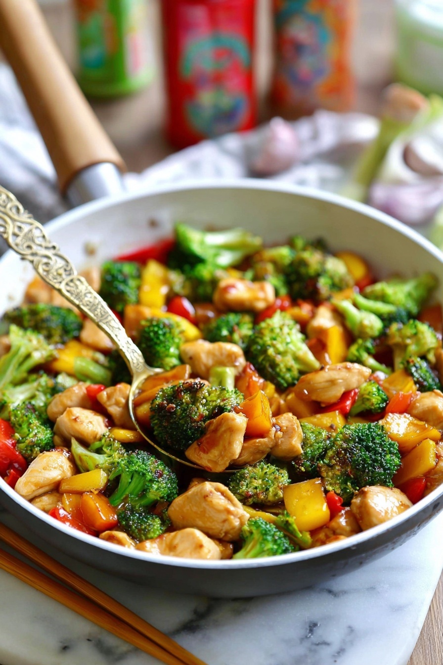 The image shows a white pan filled with a colorful stir-fry dish. The dish has three main layers: bright green broccoli florets with a fresh, bumpy texture, orange and yellow bell pepper pieces adding vibrant color and a slightly glossy texture, and light brown chicken pieces with a tender, soft look. A golden spoon with an intricate design rests in the middle of the pan, lifting some of the stir-fry. The whole scene is set on a white marbled surface, with a pair of wooden chopsticks lying beside the pan. In the background, some blurred colorful kitchen items add a cozy feel. Photo taken with an iphone --ar 2:3 --v 7 - Quick Chicken Stir Fry with Veggies, healthy chicken stir fry recipe, fast veggie stir fry, easy chicken stir fry dinner, quick stir fry dinner