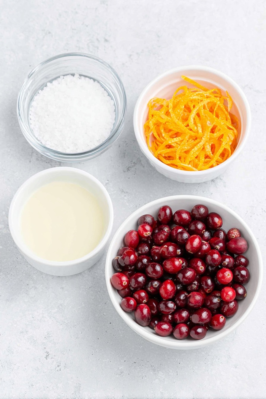 Flat lay of fresh, glossy red cranberries scattered alongside a small white ceramic bowl filled with granulated white sugar, a small white ceramic bowl containing bright, freshly squeezed orange juice, a simple white ceramic bowl with clear water, and a neat pile of vibrant orange zest strips, all arranged with perfect symmetry on a clean white marble surface, soft natural light, photo taken with an iPhone, professional food photography style, fresh ingredients, white ceramic bowls, no bottles, no duplicates, no utensils, no packaging --ar 2:3 --v 7 --p m7354615311229779997 - Homemade Cranberry Orange Sauce, easy holiday cranberry sauce, fresh cranberry sauce recipe, festive orange cranberry sauce, quick homemade cranberry sauce