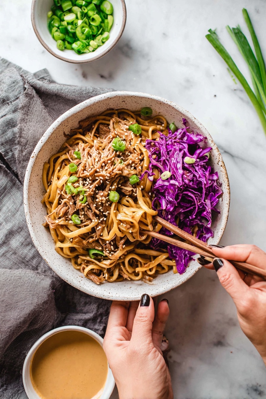 A white speckled bowl filled with a mix of thick, light brown noodles on top, shredded pieces of light brown meat underneath, and bright purple cabbage scattered on the right side and mixed throughout. Light green sliced scallions are sprinkled on top along with small white sesame seeds. A woman's hand holds the bowl from the bottom, while another woman's hand with dark nail polish uses wooden chopsticks to pick up some purple cabbage from the edge of the bowl. Nearby are two small white bowls, one with chopped green scallions and the other with a creamy light brown sauce. The setting is on a white marbled surface with a gray cloth under the bowl, and some scallions lie on the top right side. Photo taken with an iphone --ar 2:3 --v 7 - Thai Peanut Noodles with Chicken, Thai Peanut Noodles, Chicken Pad Thai, Easy Thai Noodle Recipe, Quick Chicken Noodles