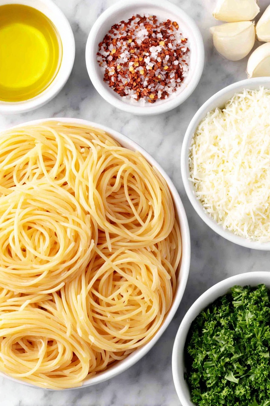 Flat lay of dried spaghetti coils arranged neatly beside a small white ceramic bowl filled with golden olive oil, a few thinly sliced garlic cloves spread out fresh and pale, a small white bowl holding bright red crushed red pepper flakes, a small white bowl of freshly grated Parmesan cheese with fine texture, and a handful of chopped vibrant green parsley leaves scattered naturally, all placed on a clean white marble surface, soft natural light, photo taken with an iPhone, professional food photography style, fresh ingredients, white ceramic bowls, no bottles, no duplicates, no utensils, no packaging --ar 2:3 --v 7 --p m7354615311229779997 - Easy Spaghetti Aglio e Olio, Spaghetti Aglio e Olio, simple Italian pasta, quick garlic pasta, flavorful Italian spaghetti