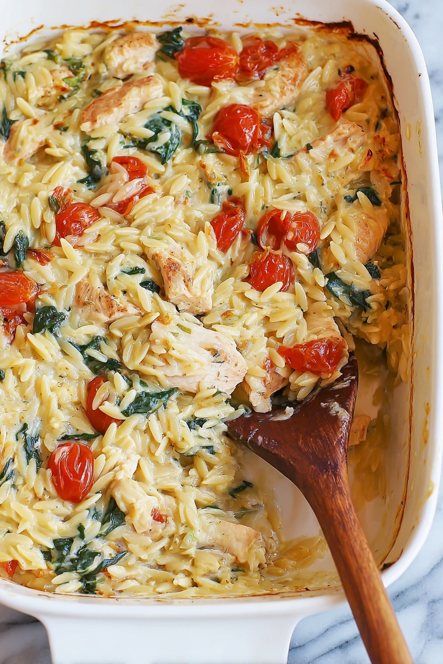 A white baking dish filled with a creamy baked pasta dish, showing about two layers with a scoop taken out from the bottom right side. The top layer has creamy, yellowish orzo pasta mixed with small roasted cherry tomatoes, chunks of light brown cooked chicken pieces, and green spinach leaves, all coated in a creamy sauce. The sides of the dish show some baked brown edges where the sauce has slightly caramelized. A wooden spoon with a long handle is inside the dish, partially covered in the pasta mixture. The dish is placed on a white marbled surface. Photo taken with an iphone --ar 2:3 --v 7 - Creamy Chicken Orzo Bake, Chicken Orzo casserole, cheesy chicken bake, easy weeknight chicken dinner, comforting baked chicken dish