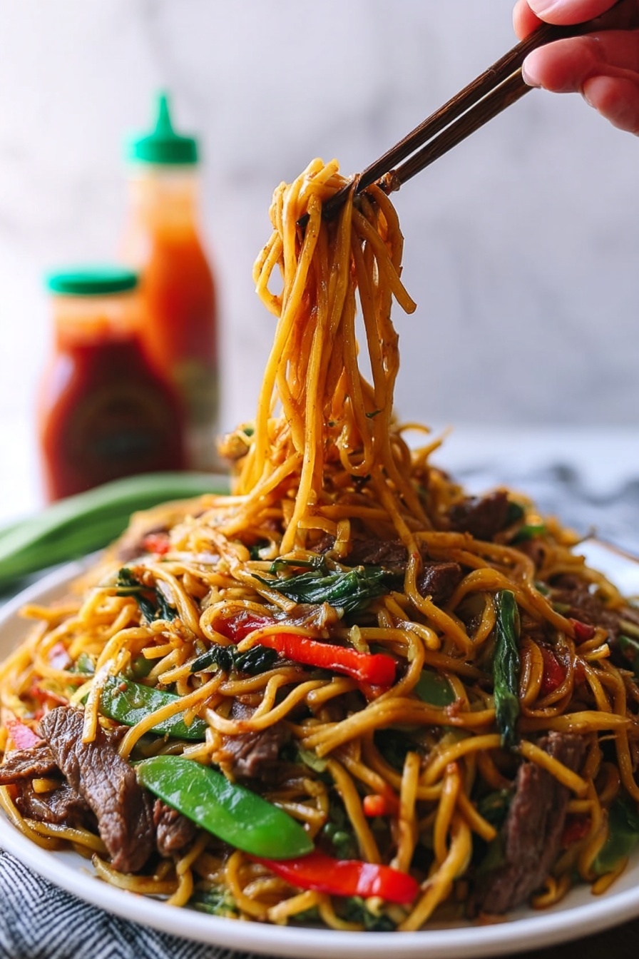 A large white plate holds a colorful stir-fry noodle dish with multiple layers. The bottom layer is long, yellow-brown noodles, glossy from sauce and slightly twisted. Mixed into the noodles are bright green snap peas and long, thin red bell pepper slices adding color contrast. Thin strips of cooked brown beef are scattered evenly on top, along with thin white strands of bean sprouts providing texture. The dish sits on a white marbled surface with blurred background that includes a blue and white bowl and bottles of sauce. photo taken with an iphone --ar 2:3 --v 7 - Beef Lo Mein Stir-Fry, beef stir-fry recipe, easy Chinese stir-fry, quick weeknight dinner, flavorful beef and vegetable stir-fry