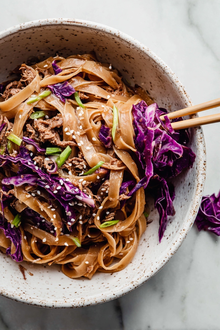 The image shows a white speckled bowl filled with a noodle dish. The bottom layer is made of wide, flat, light brown noodles coated in sauce. Mixed in and on top are shredded pieces of brown cooked meat and thin strips of bright purple cabbage, adding color contrast. Scattered over the dish are small white sesame seeds and green sliced scallions for garnish. A pair of chopsticks rests inside the bowl on the right side, holding some purple cabbage and noodles. The bowl is placed on a surface with a white marbled texture, and a small piece of purple cabbage is nearby. photo taken with an iphone --ar 2:3 --v 7 - Thai Peanut Noodles with Chicken, Thai Peanut Noodles, Chicken Pad Thai, Easy Thai Noodle Recipe, Quick Chicken Noodles