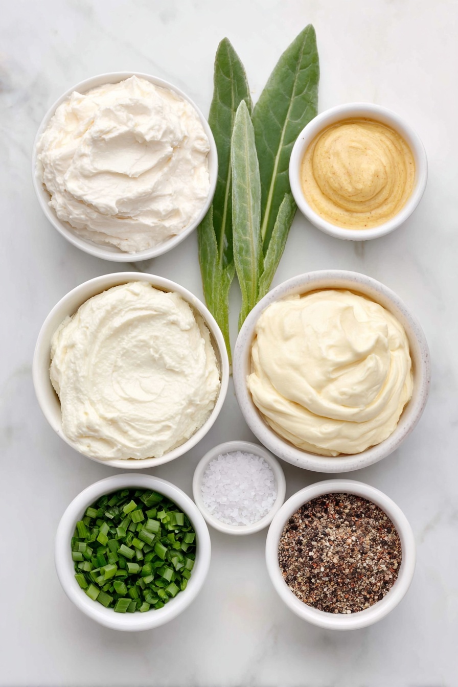 Flat lay of a small white ceramic bowl of creamy sour cream, a small white ceramic bowl with a dollop of prepared horseradish root next to a few fresh horseradish leaves, a small white ceramic bowl of smooth mayonnaise, a small white ceramic bowl containing bright green finely chopped chives, a small white ceramic bowl of golden Dijon mustard, a small white ceramic bowl with coarse kosher salt crystals, and a small white ceramic bowl with freshly ground black pepper, all arranged symmetrically and balanced, placed on a clean white marble surface, soft natural light, photo taken with an iPhone, professional food photography style, fresh ingredients, white ceramic bowls, no bottles, no duplicates, no utensils, no packaging --ar 2:3 --v 7 --p m7354615311229779997 - Creamy Horseradish Sauce for Steak, horseradish steak sauce, easy steak sauce recipe, homemade steak condiment, zesty horseradish dip