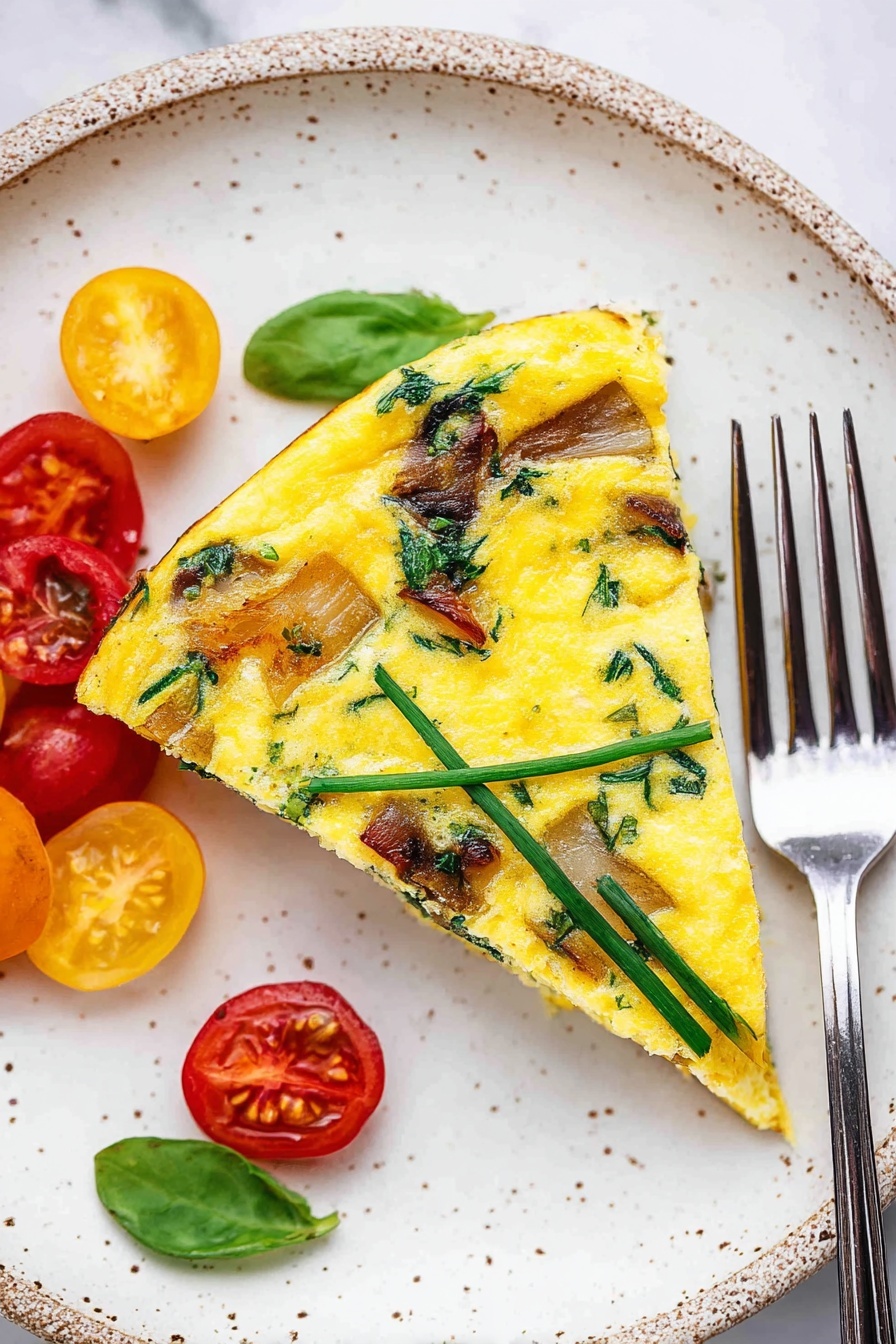 A single slice of yellow frittata with visible green herbs and brown pieces of cooked potato on top sits on a white speckled plate. The frittata’s surface is smooth and slightly glossy, showing scattered green strips of chives or scallions and browned potato chunks. To the left of the slice, there are halved red and yellow cherry tomatoes garnished with a bright green basil leaf. A silver fork rests on the right side of the plate, its tines touching one of the red cherry tomatoes. The plate is set on a white marbled surface. photo taken with an iphone --ar 2:3 --v 7 - Potato and Egg Frittata with Cherry Tomatoes, easy potato egg frittata, breakfast frittata recipe, healthy egg and potato dish, one-pan veggie breakfast