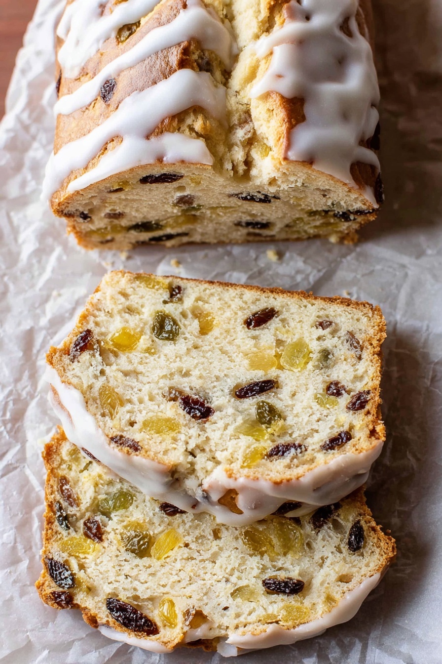 The image shows a loaf of sweet bread with a golden-brown top covered with white icing drizzled over it. The bread is sliced into three pieces, revealing a soft, light beige inside filled with bits of dark raisins and light yellow fruit pieces evenly spread throughout. The bread sits on crumpled parchment paper placed on a white marbled surface, and the slices have a slightly rough texture with visible fruit chunks inside. The crust looks thin and slightly shiny beneath the icing. Photo taken with an iphone --ar 2:3 --v 7 - Perfected German Stollen Bread, German Stollen Bread, festive holiday bread, traditional German Christmas bread, homemade Stollen loaf