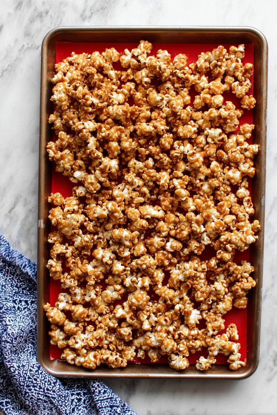 A rectangular white tin box filled with a single thick layer of caramel popcorn, where each popcorn piece is coated unevenly with a shiny golden-brown caramel glaze, showing some light and darker caramel spots. The popcorn looks puffy and slightly sticky, packed tightly inside the box which is lined with white parchment paper that curls over the sides. The box is placed on a surface with a white marbled texture. photo taken with an iphone --ar 2:3 --v 7 - Homemade Caramel Corn, caramel popcorn recipe, easy caramel popcorn, homemade popcorn snacks, crunchy caramel popcorn