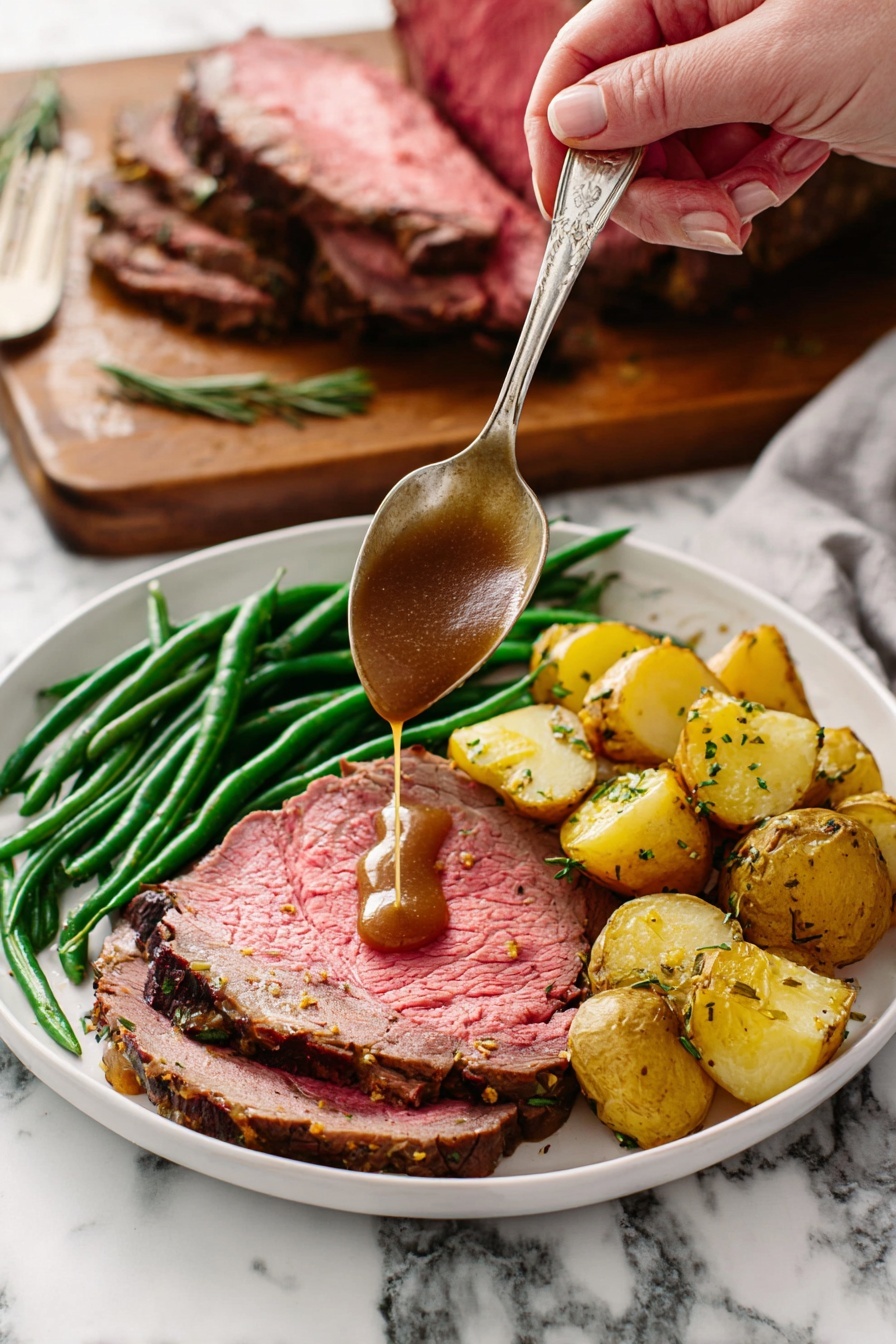 A white plate holds a meal with three layers: a large slice of pink roast beef with a browned edge forms the base layer, topped with bright green cooked green beans arranged in a neat pile along one side, and golden roasted potato chunks with herbs sit next to the green beans. A woman's hand holds a silver spoon above the beef, pouring rich brown gravy directly onto the meat. In the background, a wooden board with a large piece of roast beef resting on it is visible against a white marbled surface. Photo taken with an iphone --ar 2:3 --v 7 - Garlic Herb Prime Rib, prime rib roast recipe, garlic herb beef, tender prime rib with herbs, juicy prime rib dinner