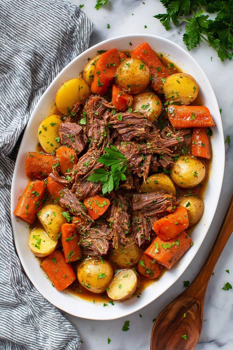The dish is served in a white oval plate filled with layers of food. The bottom layer mainly consists of golden-yellow potato halves scattered evenly around the plate’s edge, with chunky orange carrot pieces mixed in between them. On top, pulled pieces of dark brown cooked meat are placed in the center and spread slightly toward the edges, blending with the veggies. The whole dish is sprinkled with fresh green parsley bits, adding a touch of brightness. The plate is on a white marble surface with a gray striped cloth partly visible on the left and some fresh parsley on the upper right. Photo taken with an iphone --ar 2:3 --v 7 - Slow Cooker Pot Roast with Vegetables, hearty beef stew, easy slow cooker dinner, comfort food recipes, tender beef and vegetables