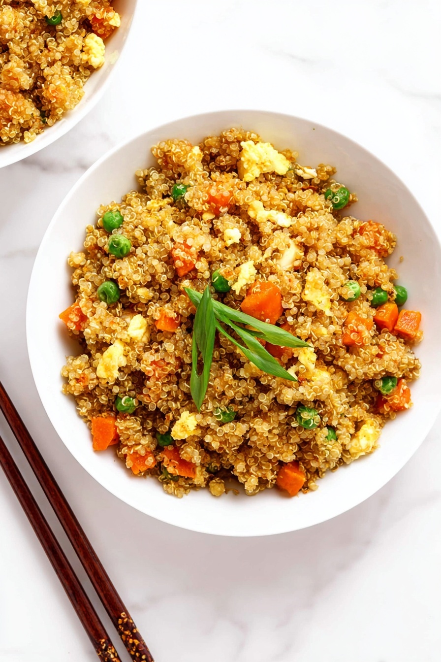 A white bowl filled with three main layers of food: the base is light brown quinoa grains, mixed evenly with small bright orange carrot cubes and green peas. There are soft, pale yellow scrambled egg pieces scattered throughout, along with small white onion chunks that have a slight shine. On top, a few fresh green onion slices add a pop of color. Next to the bowl on the white marbled surface are a pair of wooden chopsticks with a dark grain texture. The background is clean and bright, emphasizing the colors and textures of the food photo taken with an iphone --ar 2:3 --v 7 - Quinoa Fried Rice, healthy fried rice with quinoa, quick quinoa rice recipe, protein-packed vegetarian stir-fry, easy quinoa dinner