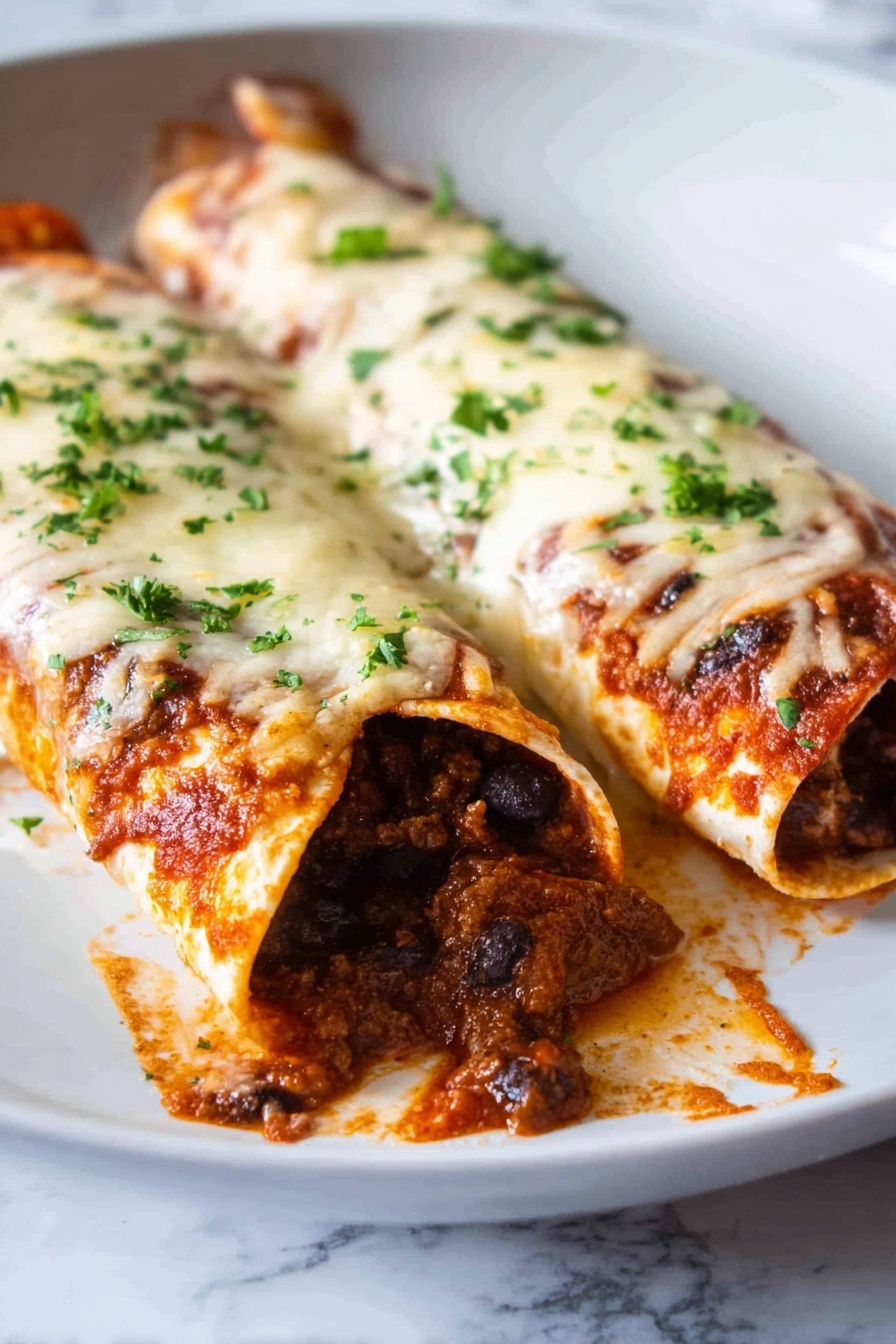 The image shows two rolled tortillas on a white plate, filled with a dark brown beef and black bean mixture. The tortillas are covered with a layer of melted white cheese that is slightly browned in spots and sprinkled with chopped green parsley. There is some red sauce visible under the cheese, giving the edges a soft orange tint. The filling is rich and chunky, spilling out a little at the open ends. The plate rests on a white marbled surface, and the scene is close-up, focusing on the texture and colors of the dish. photo taken with an iphone --ar 2:3 --v 7 - Beef Enchiladas, Beef Enchiladas Recipe, Homemade Beef Enchiladas, Easy Beef Enchiladas, Beef Enchiladas Dinner