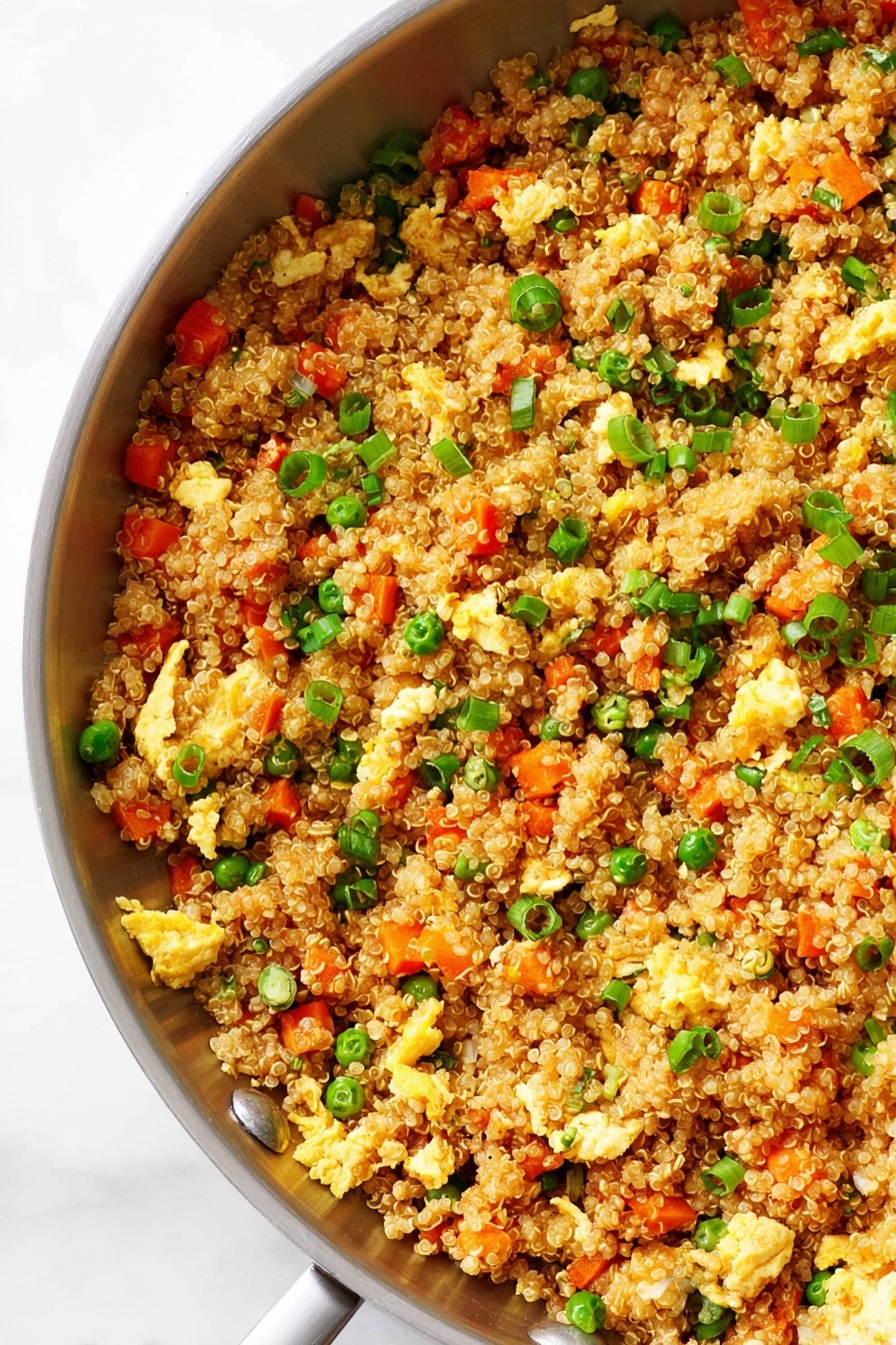 A close-up view of a silver pan filled with fried quinoa mixed with small pieces of orange carrot, green peas, chopped green onions, and light yellow scrambled egg bits scattered throughout. The quinoa grains are golden brown and fluffy, with the vegetables and eggs evenly spread, creating a colorful and textured mix. The pan sits on a white marbled surface in soft natural light. photo taken with an iphone --ar 2:3 --v 7 - Quinoa Fried Rice, healthy fried rice with quinoa, quick quinoa rice recipe, protein-packed vegetarian stir-fry, easy quinoa dinner