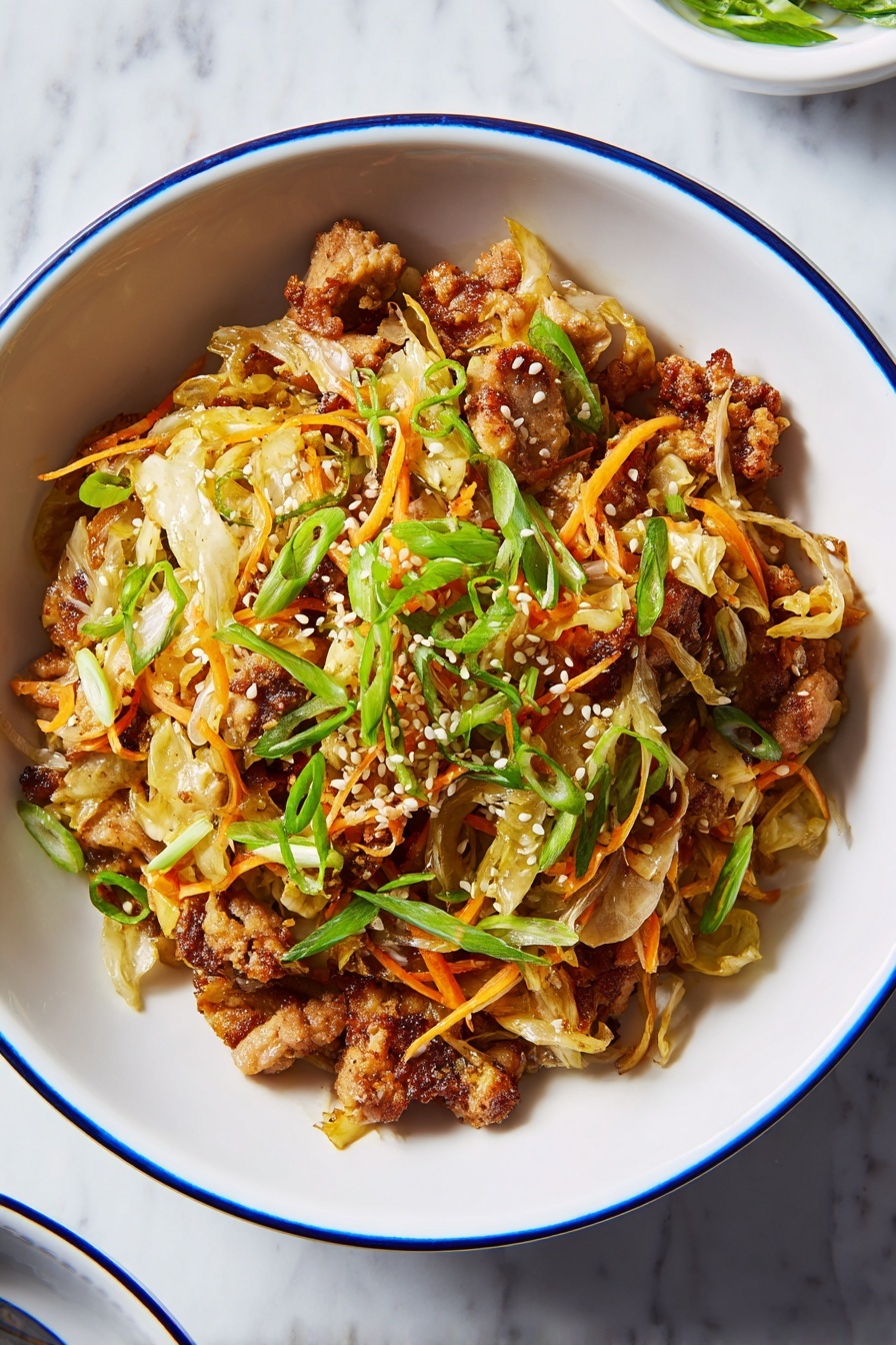 The dish is served in a white bowl with a thin blue rim, placed on a white marbled surface. It has three main layers: the bottom layer is a mix of light beige to golden-brown cooked meat pieces with a slightly crispy texture, the middle layer shows thin strips of pale yellow cabbage and orange carrot shreds, and the top layer is sprinkled with bright green sliced scallions and small white sesame seeds. The dish looks warm, textured, and colorful with a mix of soft and crunchy elements, evenly spread in the bowl. photo taken with an iphone --ar 2:3 --v 7 - Egg Roll Bowls with Ground Pork, easy egg roll bowl recipe, quick Asian ground pork dinner, healthy egg roll bowls, weeknight ground pork recipes