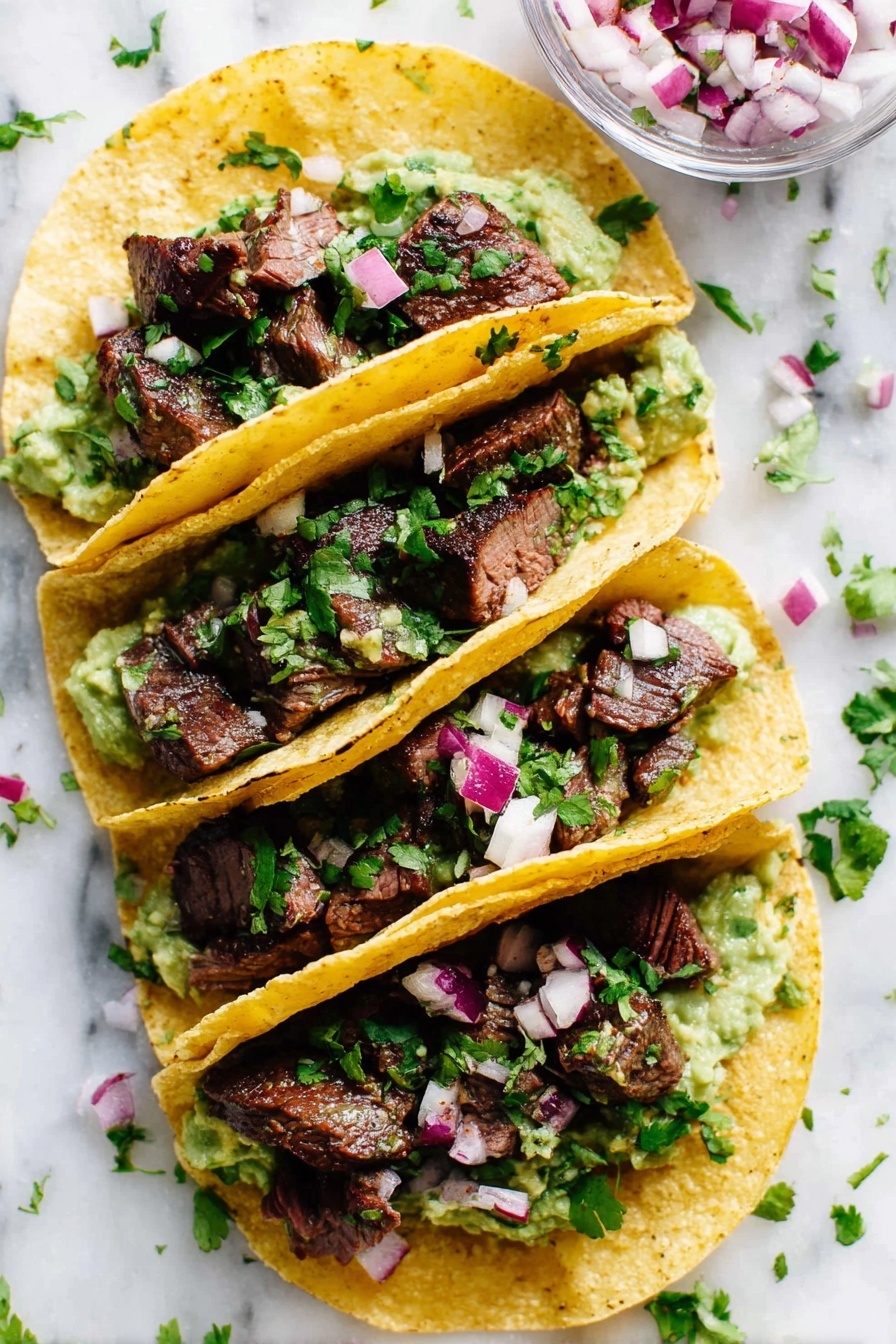 Four yellow corn tortillas are filled and folded in half, each stacked with three layers: a creamy green guacamole base, topped with chunky dark brown pieces of grilled steak, and garnished with small, diced purple and white onions along with fresh green cilantro leaves sprinkled over all. The tacos are placed closely on a white marbled surface, with some onion pieces and cilantro leaves scattered around. A clear glass bowl with diced red onions is partially visible in the upper right corner. The photo taken with an iphone --ar 2:3 --v 7 - Marinated Mojo Steak Tacos, steak tacos with citrus marinade, flavorful taco recipes, easy steak tacos, savory taco fillings