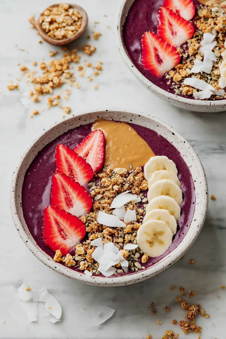 Two white speckled bowls filled with a thick, deep purple smoothie layer as the base. On top, there is a middle strip of tan peanut butter drizzled down the center. To the right of the peanut butter are slices of banana in a row, creamy yellow with small black seeds visible. On the left side are bright red strawberry slices fanned out. Sprinkled generously across the top and around the fruit is a layer of crunchy granola, with golden brown clusters mixed with pumpkin seeds. Large white coconut flakes are scattered on the edges, adding texture and contrast. The bowls are placed on a white marbled surface with some granola and coconut flakes scattered around. Photo taken with an iphone --ar 2:3 --v 7 - Healthy Açaí Bowl, nutritious smoothie bowl, quick breakfast recipe, healthy fruit bowl, energizing acai bowl