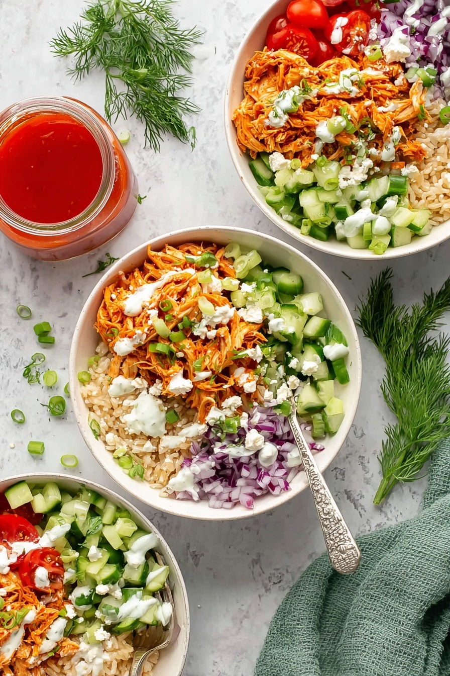 The image shows three white bowls filled with layered food on a white marbled surface. Each bowl has a bottom layer of light brown rice, topped with shredded orange chicken on one side. Around the chicken, there are sections of bright green chopped cucumber, shredded orange carrots, halved red cherry tomatoes, and finely chopped purple onions. White creamy dressing is drizzled over the top, along with small white crumbles of cheese and green sliced scallions scattered across the layers. A silver fork with a white and black handle rests inside each bowl. Nearby, there is a small glass jar filled with bright red sauce and a green cloth napkin, along with sprigs of fresh dill for decoration. Photo taken with an iphone --ar 2:3 --v 7 - Buffalo Chicken Rice Bowls with Ranch Dressing, buffalo chicken rice bowl, spicy buffalo chicken recipe, easy chicken rice bowl, ranch dressing chicken bowl