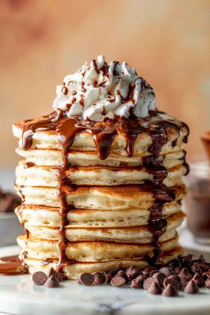 A tall stack of nine thick, golden brown pancakes is shown on a white marbled surface, each pancake fluffy with slightly crisp edges. Chocolate syrup slowly drips down the sides of the stack, creating shiny dark brown streams over the light tan pancakes. A small pile of chocolate chips is scattered around the base of the stack, adding texture and darker brown spots. On top, a swirl of white whipped cream sits high and soft, with more chocolate syrup drizzled over the cream in thin lines. The background is softly blurred with warm tones giving a cozy feel. photo taken with an iphone --ar 2:3 --v 7 - Fluffy Chocolate Chip Pancakes, best fluffy pancakes with chocolate chips, easy chocolate chip pancake recipe, how to make fluffy chocolate chip pancakes, breakfast pancakes with chocolate