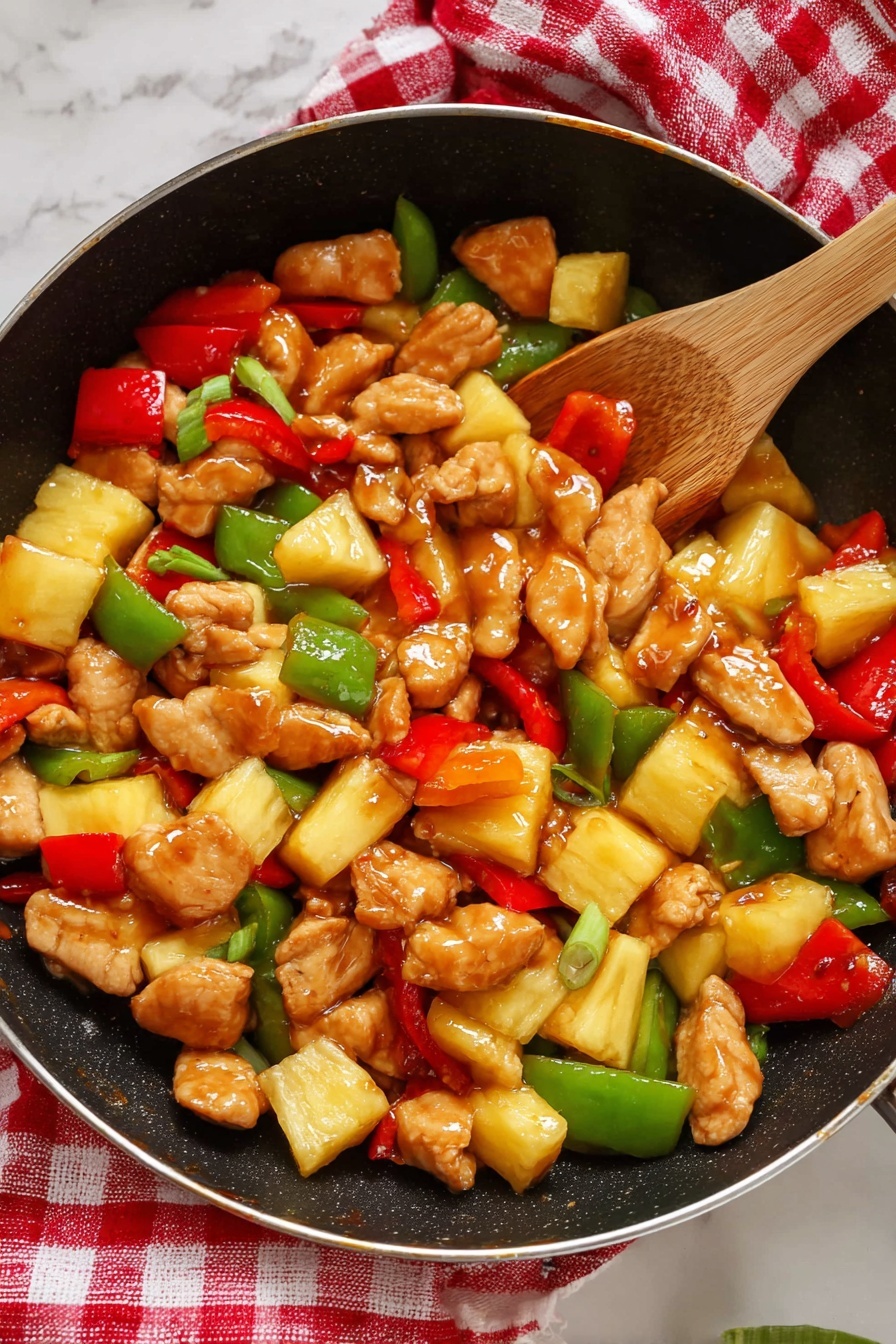 A white oval plate contains a dish with two main layers. The bottom layer is a bed of steamed white rice, with soft, fluffy grains. On top, there is a thick mixture of bite-sized golden brown chicken pieces coated in a shiny sauce, large chunks of bright yellow pineapple, green bell pepper pieces with a smooth shine, and irregular slices of red bell pepper. The vegetables and chicken are mixed evenly, creating a colorful and glossy topping over the rice. The plate sits on a white marbled surface, with a red and white checkered cloth partially visible to the side. Photo taken with an iphone --ar 2:3 --v 7 - Sweet and Sour Chicken, Easy Sweet and Sour Chicken, Homemade Sweet and Sour Chicken, Quick Sweet and Sour Chicken, Best Sweet and Sour Chicken