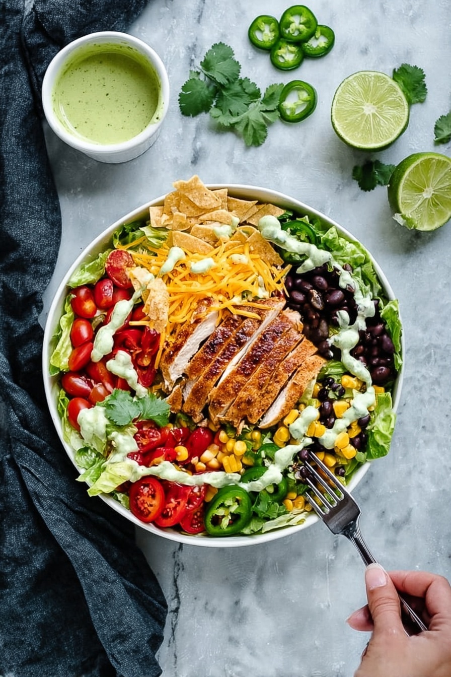A white bowl filled with a colorful layered salad placed on a white marbled surface; the bottom layer shows fresh green lettuce leaves, topped with bright red cherry tomatoes, black beans mixed with yellow corn, sliced red bell peppers, black olive slices, and shredded yellow and white cheese spread around the edges. In the center, there is a piece of golden brown grilled chicken sliced neatly into strips. On top of the salad, there are dollops of white sauce and green guacamole, some tortilla strips, and fresh cilantro leaves scattered for garnish. Lime wedges sit on the side of the bowl. A woman's hand holding a fork approaches from the right, with sliced green jalapeño pieces nearby. A small white bowl containing green dressing rests on a dark cloth in the top left corner. photo taken with an iphone --ar 2:3 --v 7 - Southwest Chicken Salad with Cilantro Lime Dressing, Southwest chicken salad, cilantro lime dressing recipe, healthy chicken salad, quick Mexican-inspired salad