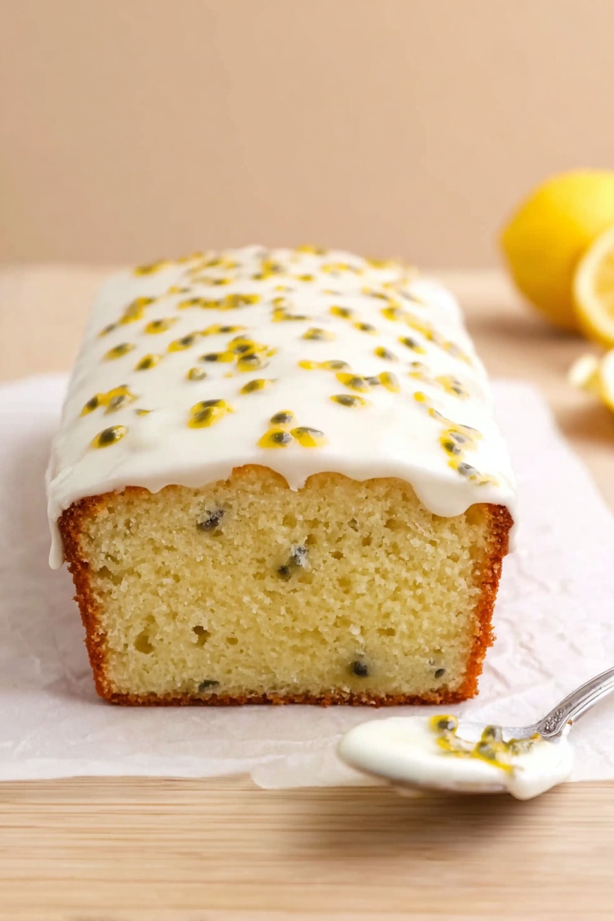 A loaf cake is shown from the front with a thick layer of white icing on top that has yellow passion fruit seeds scattered over it. The cake's texture is soft and light yellow inside with a slightly browned crust at the bottom. The cake rests on white parchment paper placed on a light wood surface, with a spoon holding some icing to the right and a halved yellow lemon in the blurred background. The overall background is a smooth, pale beige color. photo taken with an iphone --ar 2:3 --v 7 - Passion Fruit Lemon Drizzle Cake, tropical lemon cake, easy citrus dessert, moist passion fruit cake, fruity drizzle cake